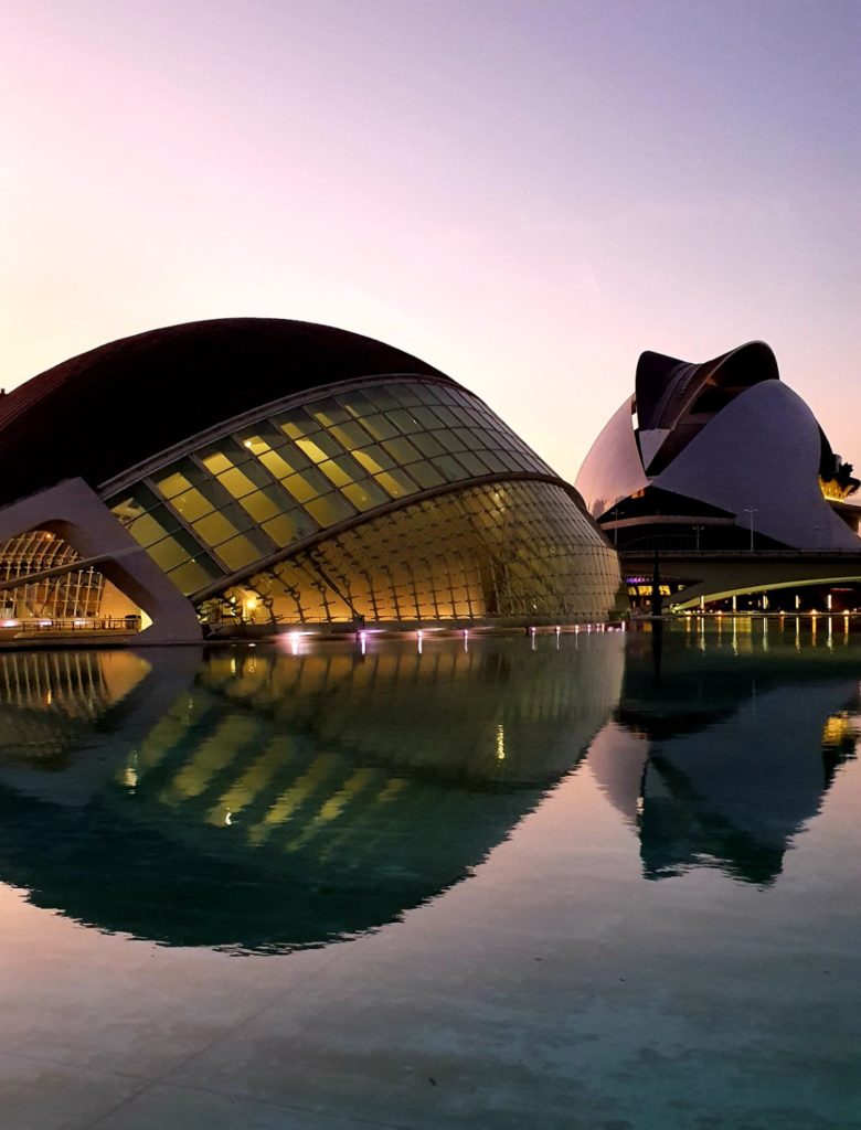 Nwoczesna cześć Walencji, modernistyczne budynki rozświetlone wieczorem.