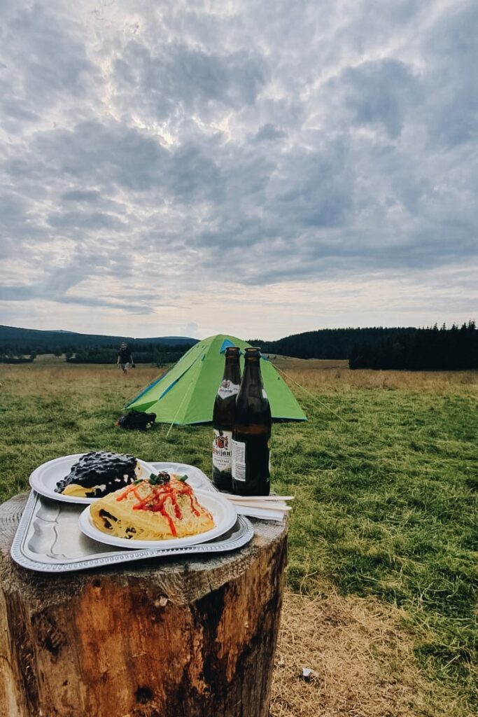 jedzenie na tle gór i namiotu.