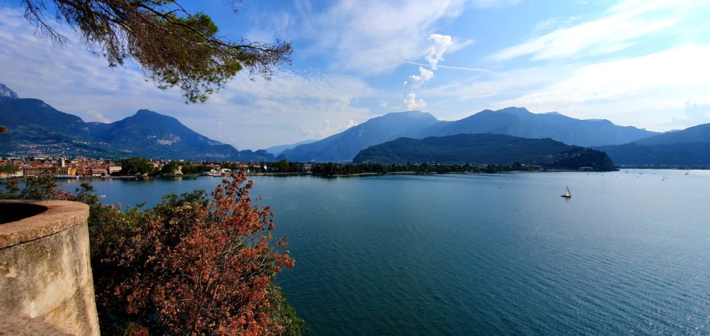 Panorama Jeziora Garda, żaglówka na spokojnym jeziorze.