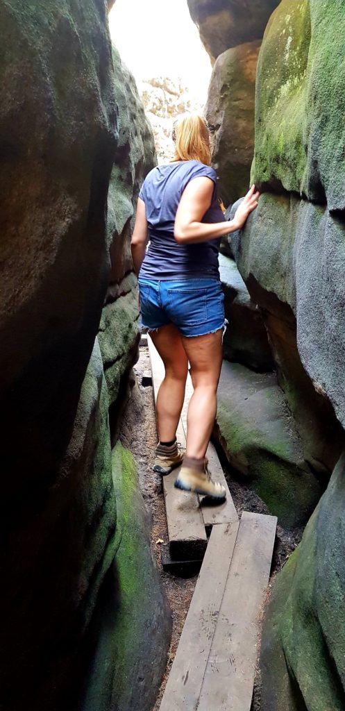 Dziewczyna na wąskim przesmyku w Błędnych Skałach. Góry stołowe.