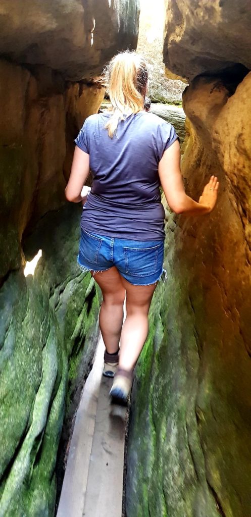 Dziewczyna na wąskim przesmyku w Błędnych Skałach. Góry stołowe.