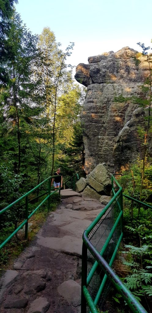 Góry Stołowe, ścieżka na Szczeliniec i dziewczyna idąca po skalnych schodach.