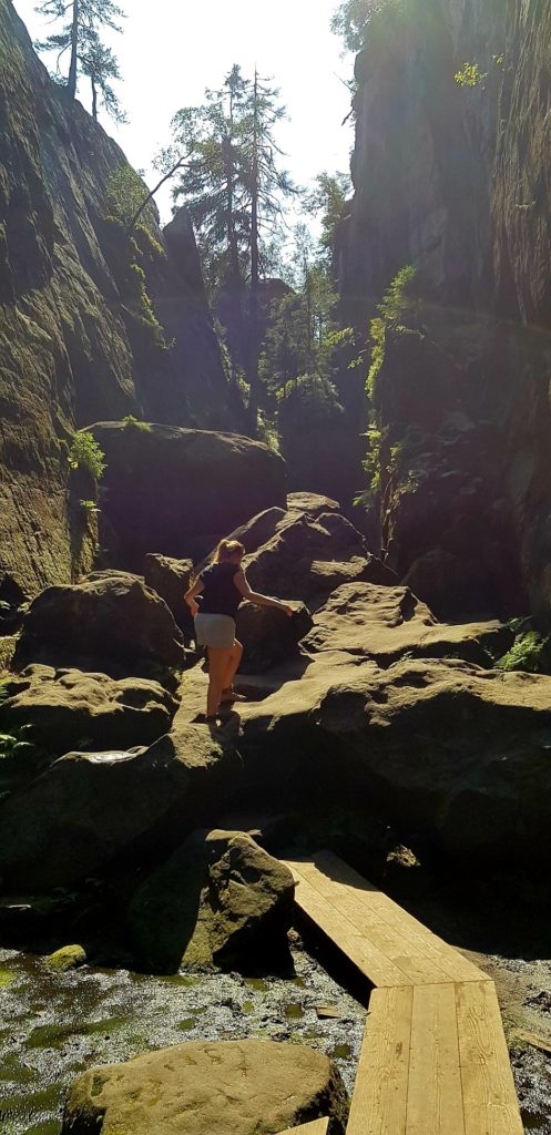 Dziewczyna wchodząca na skały w labiryncie na Szczelińcu.