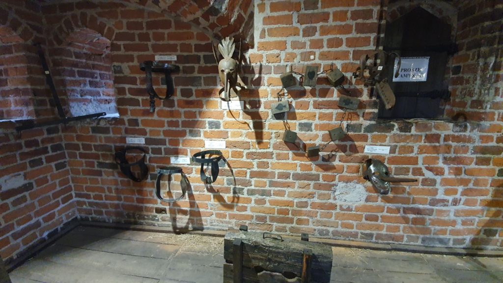 Toruńskie muzeum narzędzi tortur, widok na ścianę z maskami
