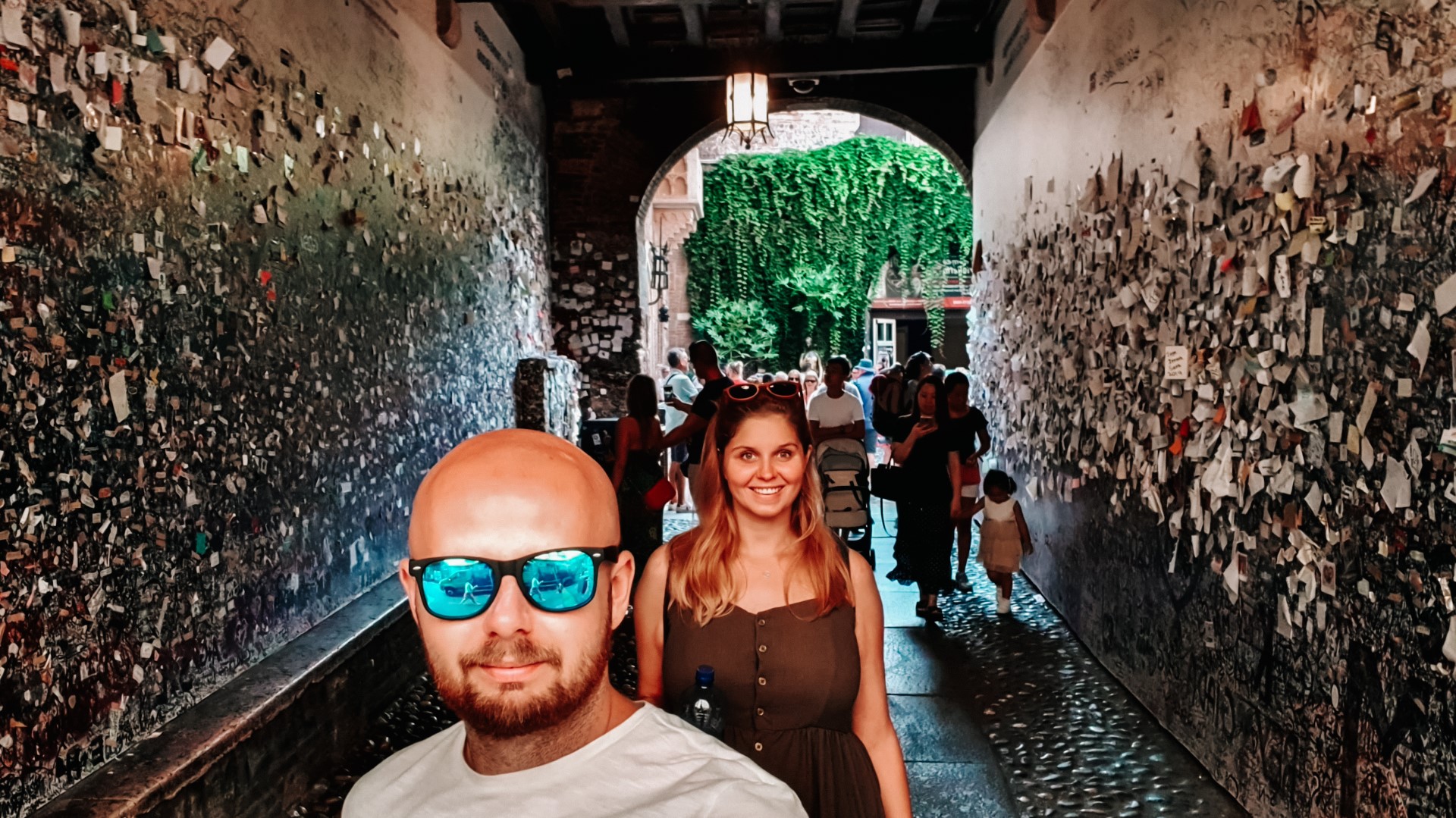 Para w przejściu do domu Julii w Weronie, ściany obwieszone listami.