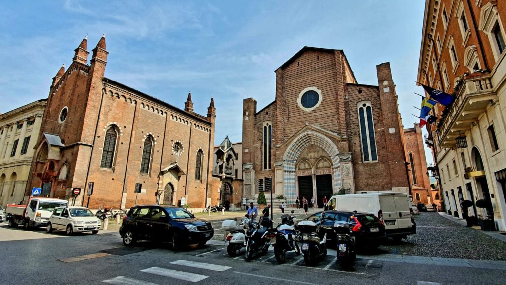Ulica i zaparkowane skutery przed kościołem w Weronie.