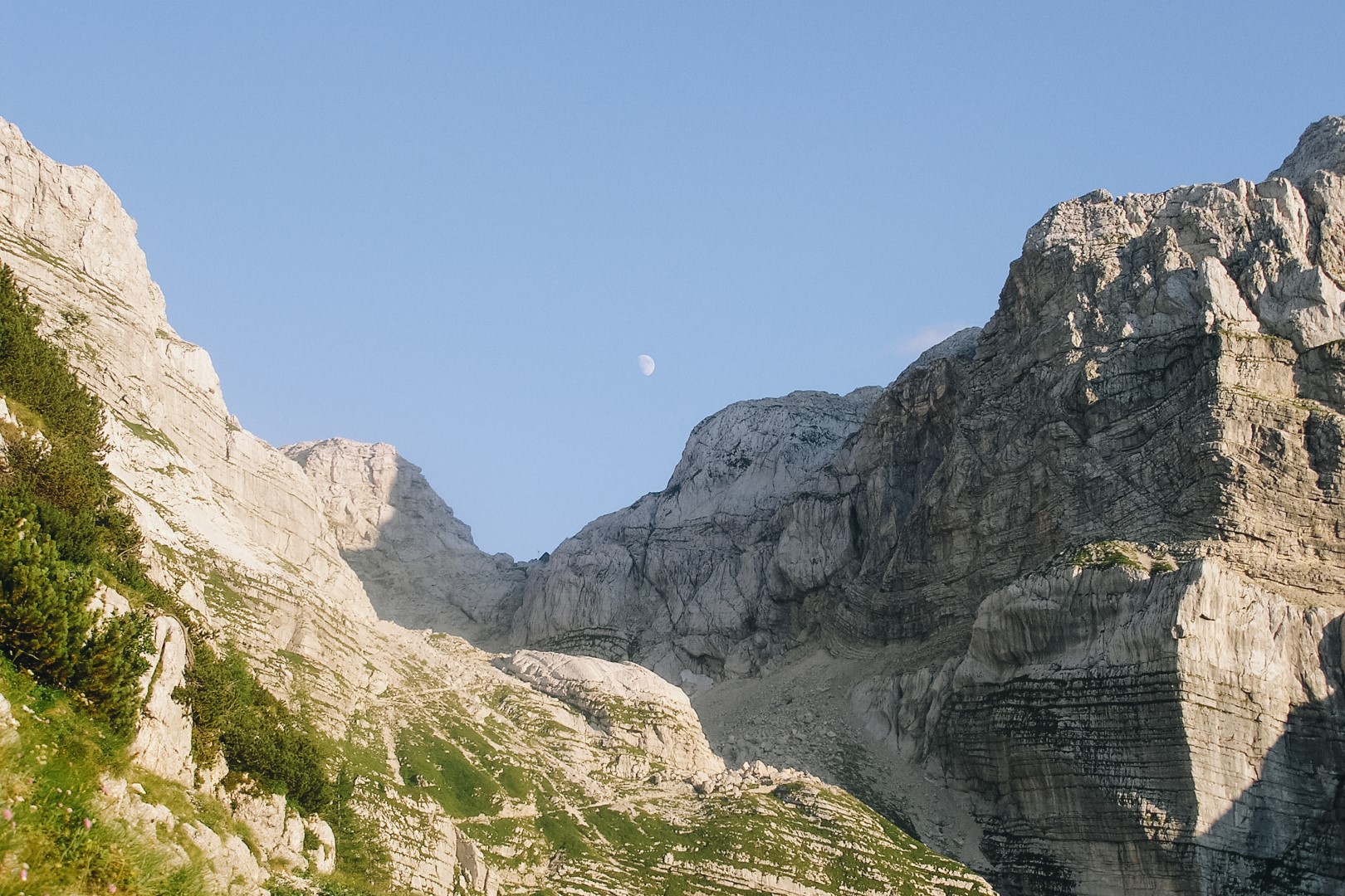 Widok na Alpy Julijskie ze szlaku na Triglav. Księżyc nad górami.