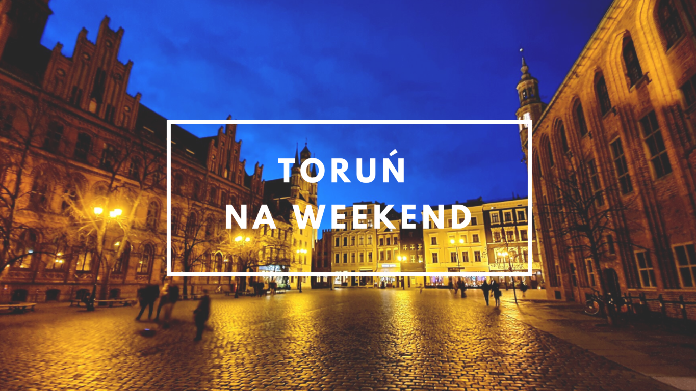 Widok starówki w Toruniu nocą ładnie oświetlony ratusz i sąsiednie budynki