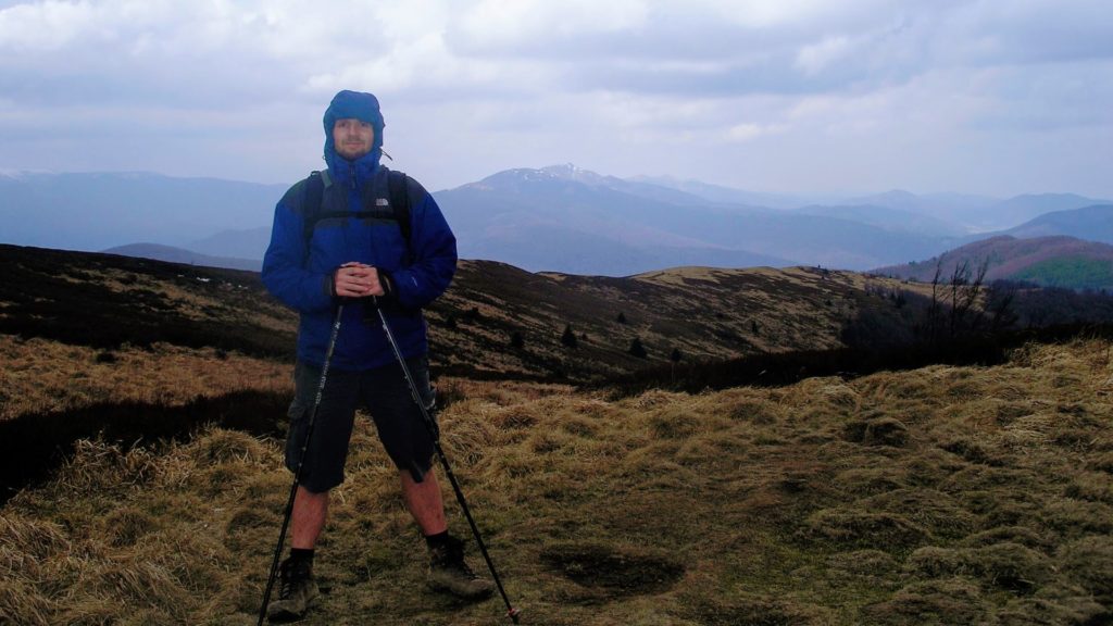 Mężczyzna w kurtce z kijami trekkingowymi w górach, Bieszczady