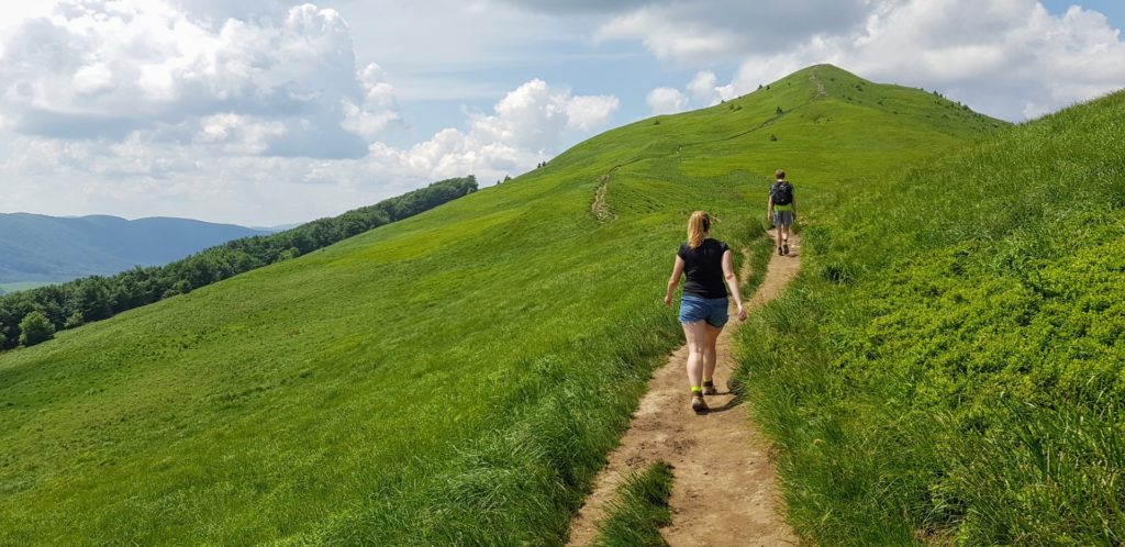 Dziewczyna idąca szlakiem w zielonych Bieszczadach.