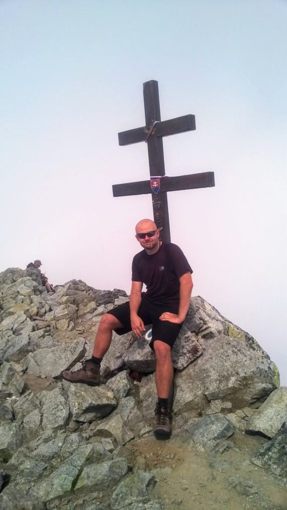 Mężczyzna siedzący na szczycie Krywania w Tatrach Słowackich.