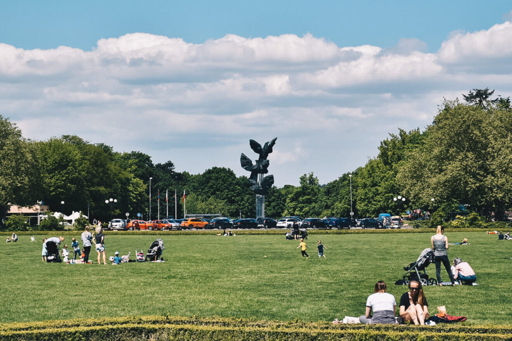 Ludzie wypoczywający na trawniku na Jasnych Błoniach.