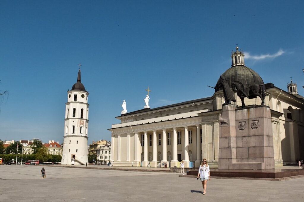 Dziewczyna idąca przez Plac Katedralny w Wilnie.