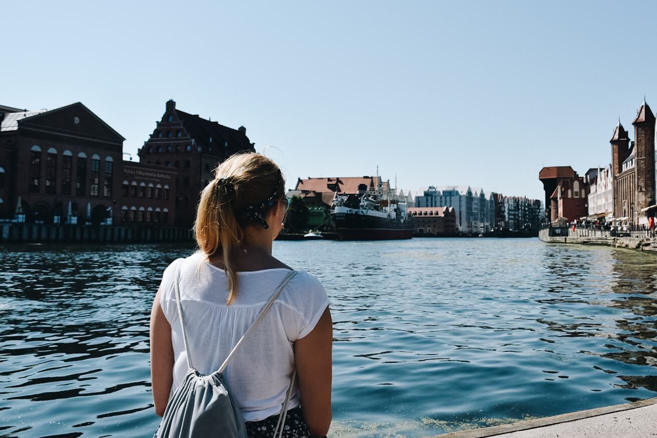 Turystka patrząca na Gdańsk na nabrzeżu Motławy.