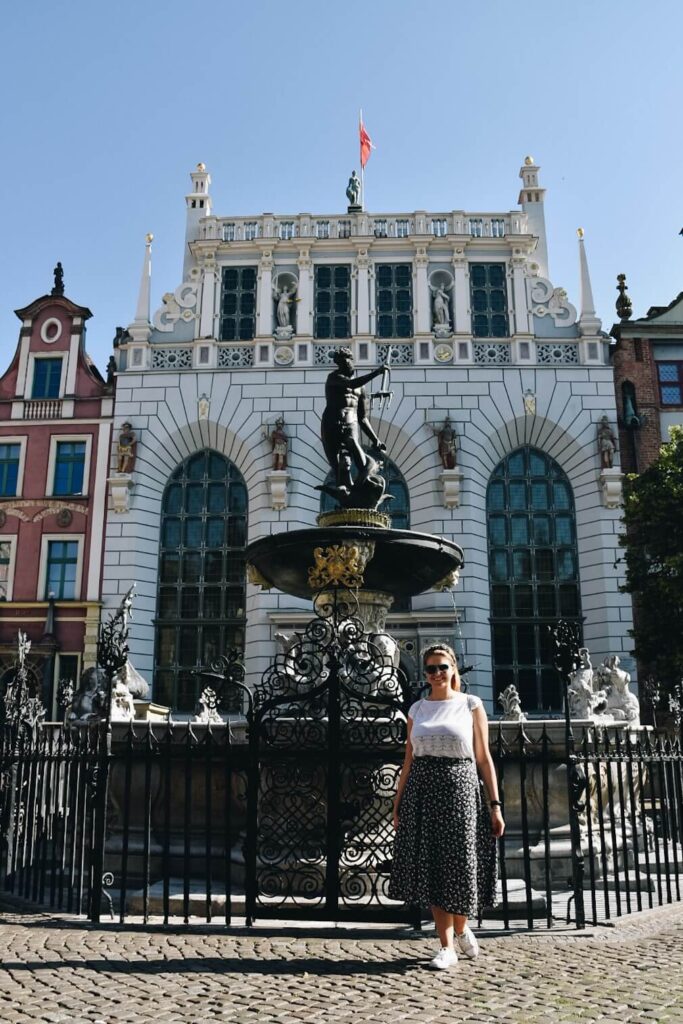 Turystka pod fontanną Neptuna w Gdańsku.