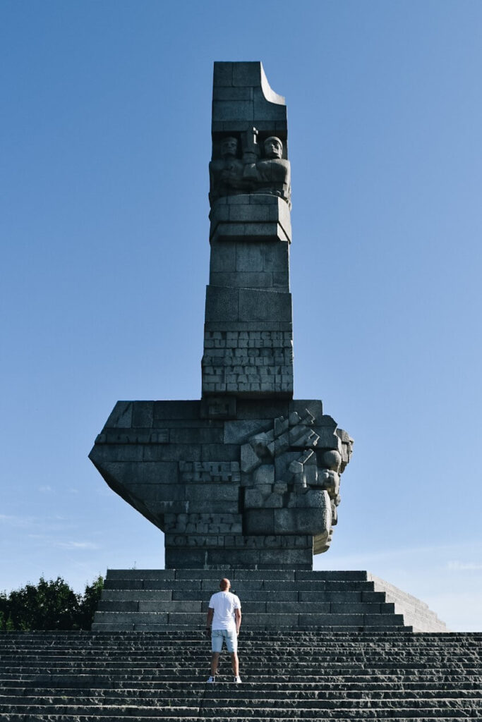 Turysta pod pomnikiem Obrońców wybrzeża na Westerplatte.