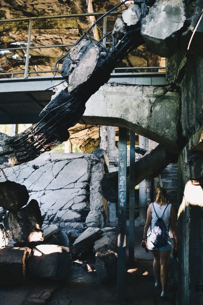 Riuny koszar na Westerplatte od środka i zwiedzająca je turystka.