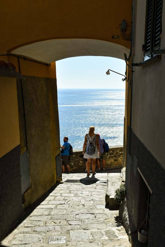 Turystka wychodząca na taras widokowy na morze w miasteczku Corniglia.