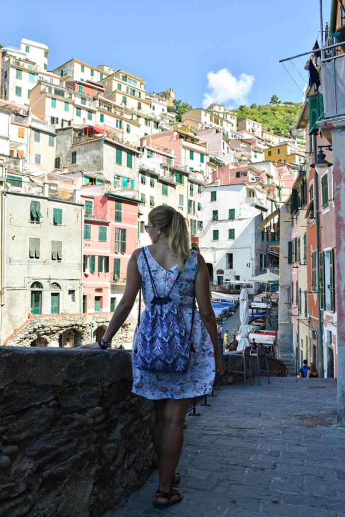 Turystka na ulicach Cinque Terrre. Widok na kolorowe kamienice.