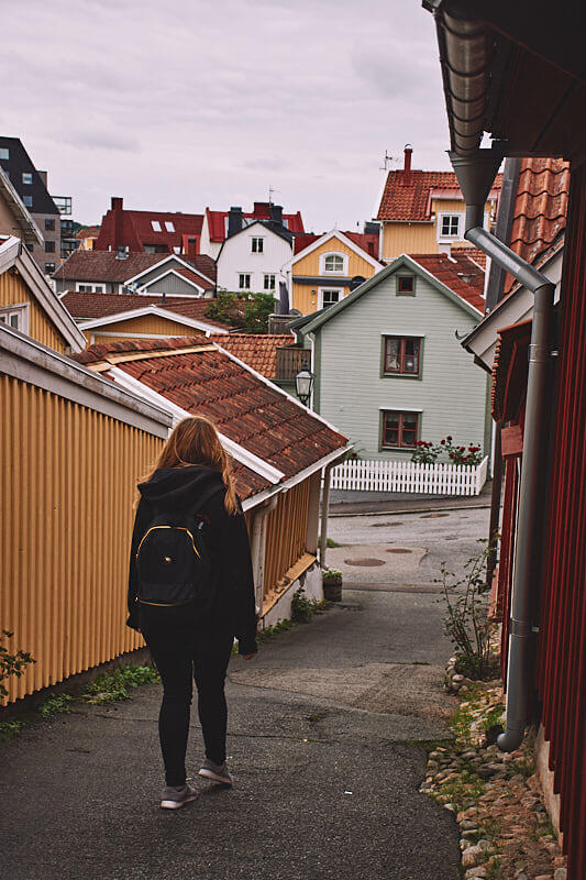 Karlskrona, turystka pomiedzy kolorowymi domkami.